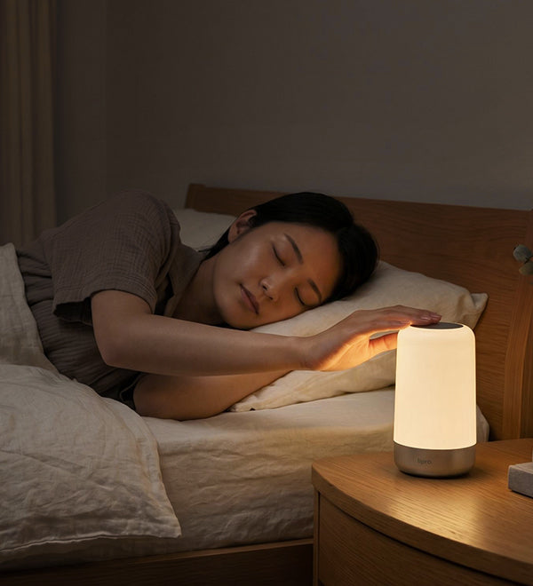 A person reaching for Sleep Light from bed