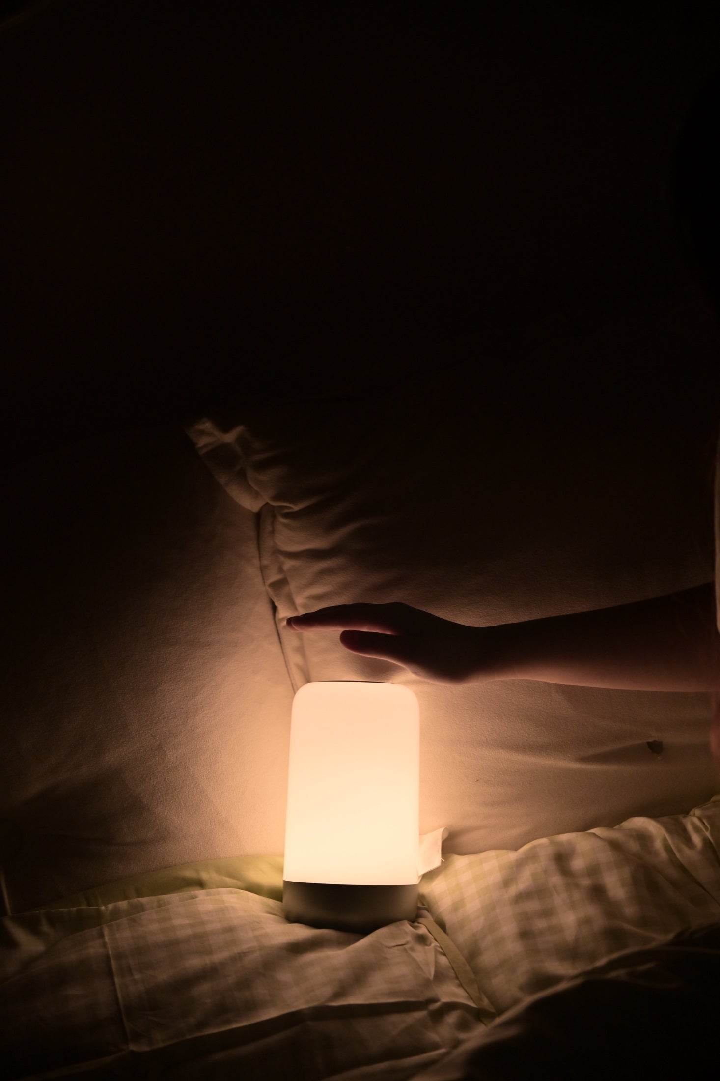 A hand reaching for the upper touch surface of Sleep Light